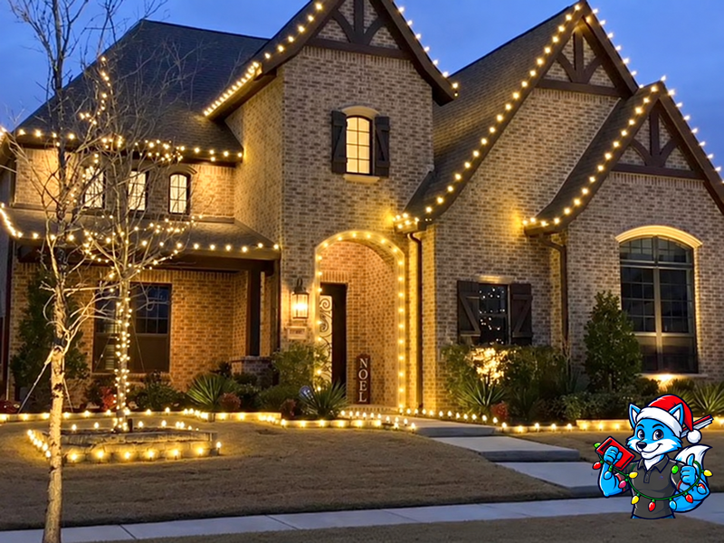 Brick home with roofline, tree and entryway Christmas lights