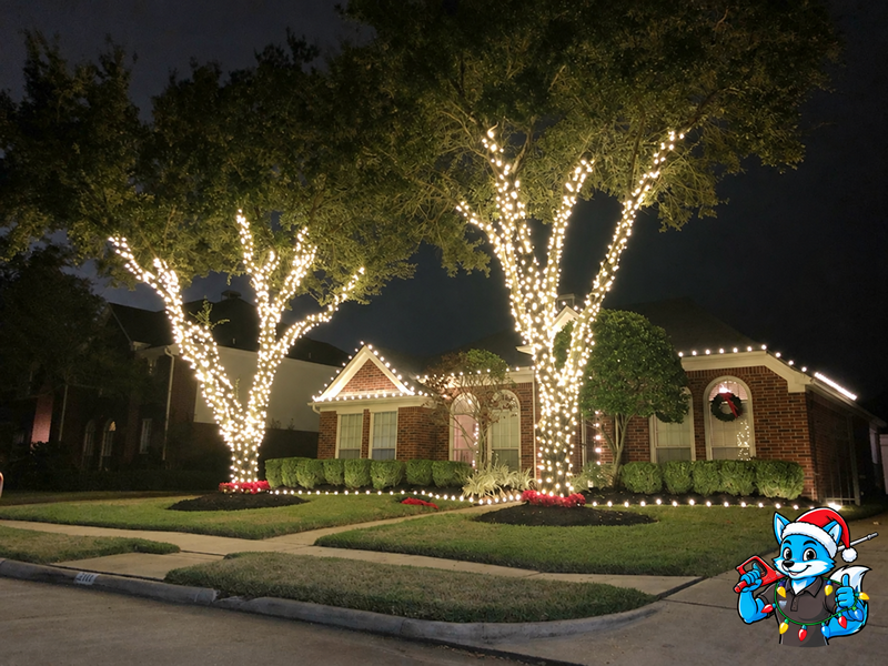 Home with trees wrapped in warm white Christmas lights